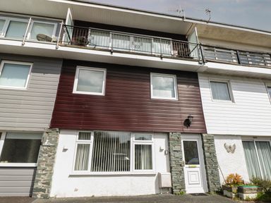Front view of a multi-story house with brown and white exterior panels and balcony at The Heights in Bowness