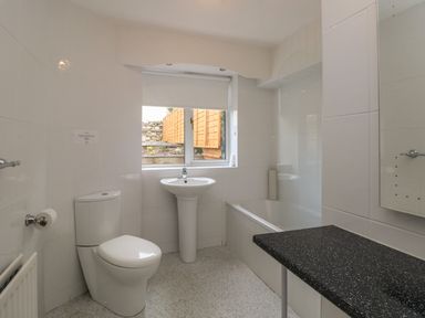 A bathroom with a toilet sink bathtub and a window at The Heights in Bowness
