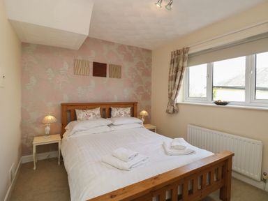 A bedroom with a wooden bed and bedside tables with lamps at The Heights in Bowness