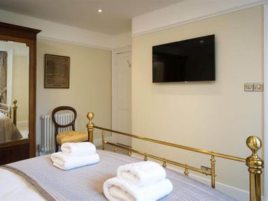 A bedroom with a brass bed frame and folded towels on the bed at Loughrigg Cottage in Ambleside