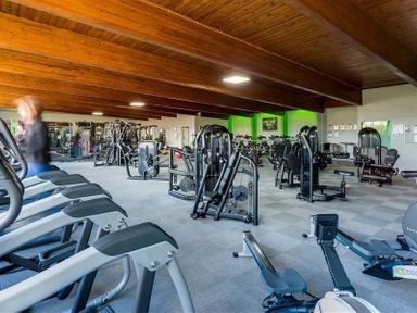 A gym with cardio machines and weight training equipment at The Blithe Hare in Troutbeck Bridge