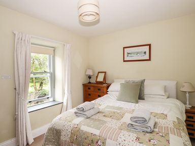 A bedroom with a double bed and folded towels on the bed at The Mews in Ambleside