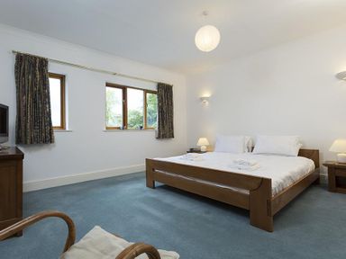 A bedroom with a wooden bed and blue carpet at March House in Windermere