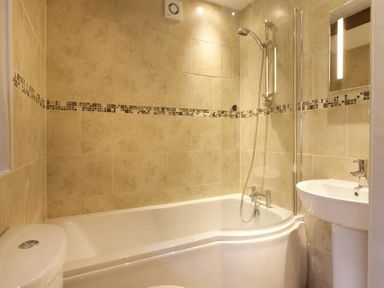 A bathroom with a bathtub shower combination toilet and pedestal sink at Wythebank in Langdale