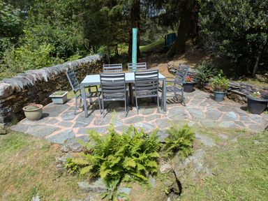 A garden with a table and chairs at Wythebank in Langdale