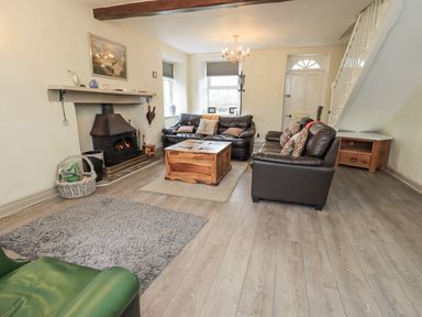 A living room with a fireplace and sofas at Smithy Cottage at Bowland Bridge Bowness