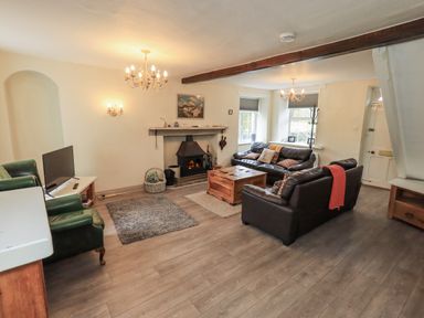 A living room with a sofa and television at Smithy Cottage at Bowland Bridge Bowness