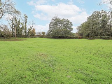 An outdoor area with grass and trees at Smithy Cottage at Bowland Bridge Bowness