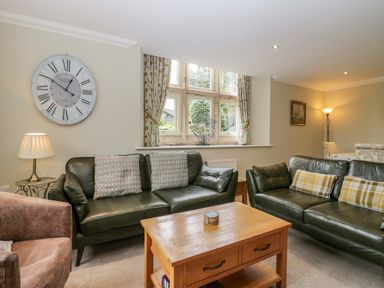 A living room with sofas, a table, and a clock at Middlerigg in Troutbeck