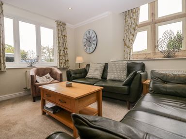 A living room with a sofa, armchair and coffee table at Middlerigg in Troutbeck