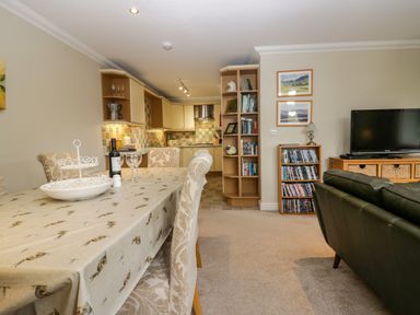 An open plan living and dining area with a table and kitchen at Middlerigg in Troutbeck