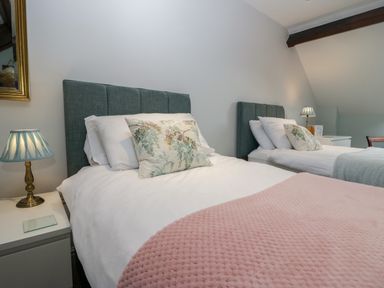 A bedroom with two beds and a lamp at Middlerigg in Troutbeck