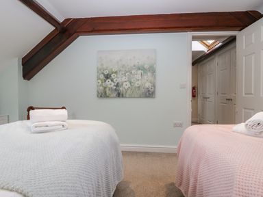 A bedroom with two beds and a painting at Middlerigg in Troutbeck