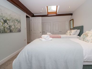 A bedroom with two beds and a painting at Middlerigg in Troutbeck
