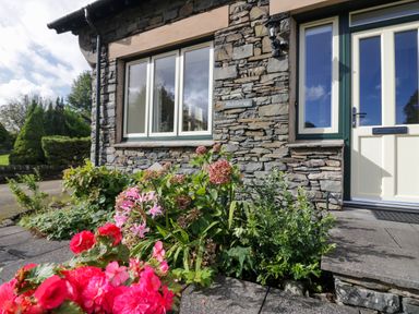 An outdoor area with flowers and stone wall at Middlerigg in Troutbeck