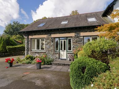 A house with a stone exterior and flowers in planters at Middlerigg in Troutbeck