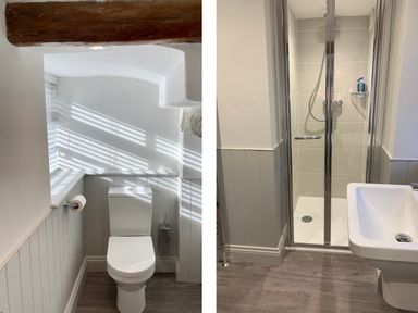 A bathroom with a toilet under a wooden beam and a shower with glass doors and a white sink at Bank Barn at Rusland in Grizedale