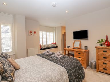 A bedroom with a bed folded towels and wooden furniture at Rossett Holme in Ambleside