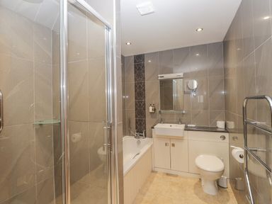 A bathroom with a shower enclosure bathtub sink toilet and heated towel rail at Rossett Holme in Ambleside