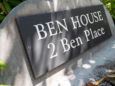 A stone plaque with the text Ben House 2 Ben Place surrounded by greenery at Ben House in Grasmere