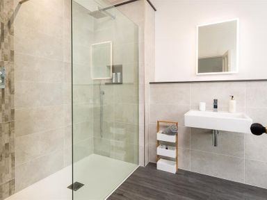 A bathroom with a walk in shower and a wall mounted sink at Ben House in Grasmere