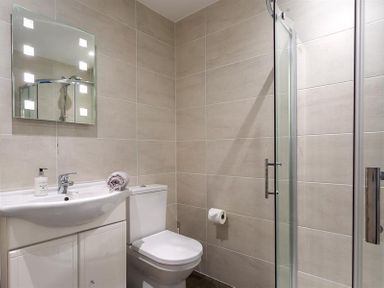 A bathroom with a sink cabinet toilet shower enclosure and mirror at Ben House in Grasmere