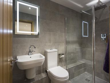 A bathroom with a sink toilet and glass enclosed shower at Tall Trees in Bowness