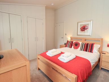 A bedroom with a bed and wardrobe at Thie Loghey in Hawkshead