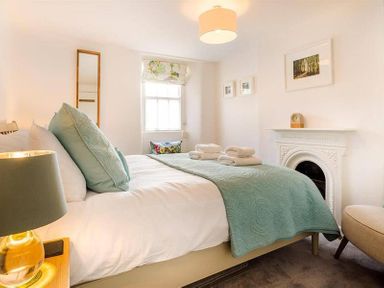A bedroom with a bed and folded towels near a fireplace at Lettera in Ambleside
