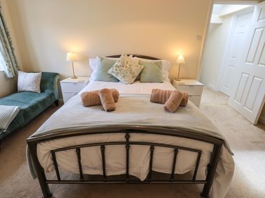 A bedroom with a metal bed frame and rolled towels on the bed at Laal Field House in Keswick