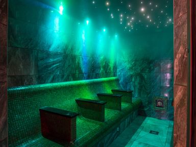 A tiled steam room with bench seating and star-like ceiling lights at Orrest Range in Windermere
