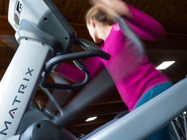 A person using a matrix elliptical machine in a gym