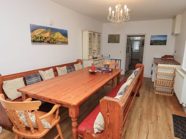 A dining room with a wooden table and benches with cushions at Number Twenty in Keswick