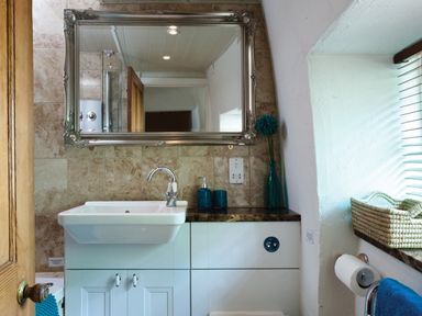 A bathroom with a sink and mirror above it at Burrow Cottage in Bowness