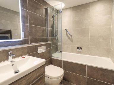 A bathroom with a sink, toilet, bathtub, and shower at Pudding Cottage in Ambleside