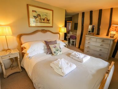 A bedroom with a bed two bedside tables two lamps a chest of drawers and a dressing table at Low Cartmell Fold in Crosthwaite