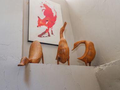Three wooden duck sculptures on a ledge with a framed fox print on the wall behind at Low Cartmell Fold in Crosthwaite