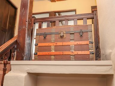 A wooden staircase with an antique trunk at the landing at Low Cartmell Fold in Crosthwaite