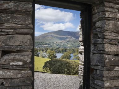 A view of hills trees and a lake through a stone doorway at Tent Lodge in Coniston