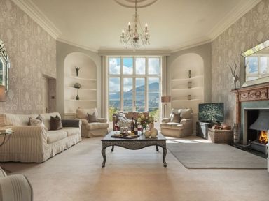 A living room with sofas armchairs coffee table and fireplace at Tent Lodge in Coniston