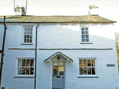 Front view of a white cottage with windows and a door at Pollys Cottage in Langdale