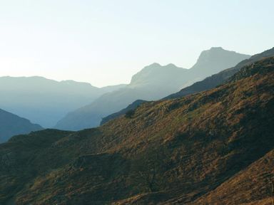A mountain landscape with ridges and valleys under a clear sky at Pollys Cottage in Langdale