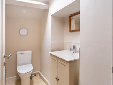 A small bathroom with a toilet a sink vanity and a mirror at Barn Cottage Bassenthwaite near Keswick
