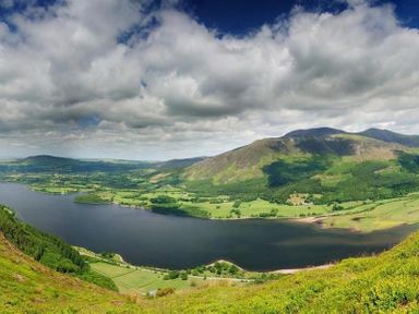 A valley with a large lake surrounded by green fields and hills under a cloudy sky at Barn Cottage in Bassenthwaite near Keswick