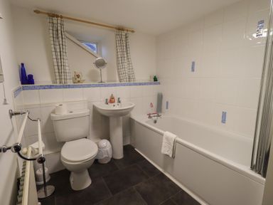 A bathroom with a toilet a sink and a bathtub with a towel at Birchcroft in Ambleside