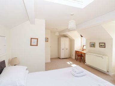 A bedroom with a bed lamp wardrobe desk and chair at Robin Cottage in Troutbeck