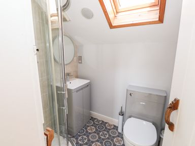 A bathroom with a shower enclosure sink with cabinet toilet and skylight at Robin Cottage in Troutbeck