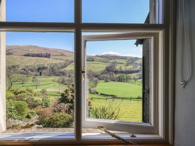 A window opening to a view of green fields and hills at Boxwood Cottage in Troutbeck