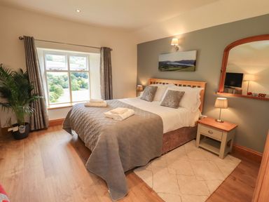 A bedroom with a bed and window at Boxwood Cottage in Troutbeck