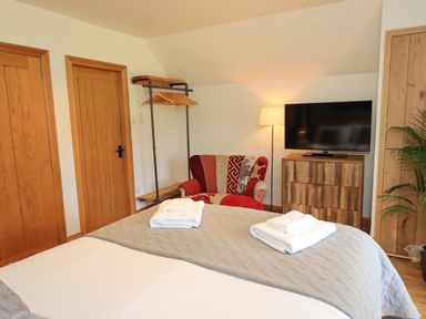 A bedroom with a bed and television at Boxwood Cottage in Troutbeck
